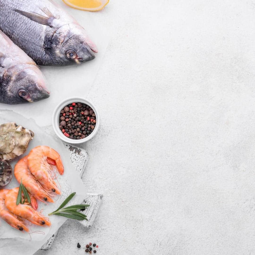 Seafood, shrimp and fish, all contains L glutamine, on a table with lemon and spices. Glutamine rich foods to eat like fish. 