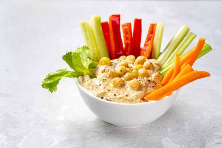 close up plate with hummus dip vegetable sticks