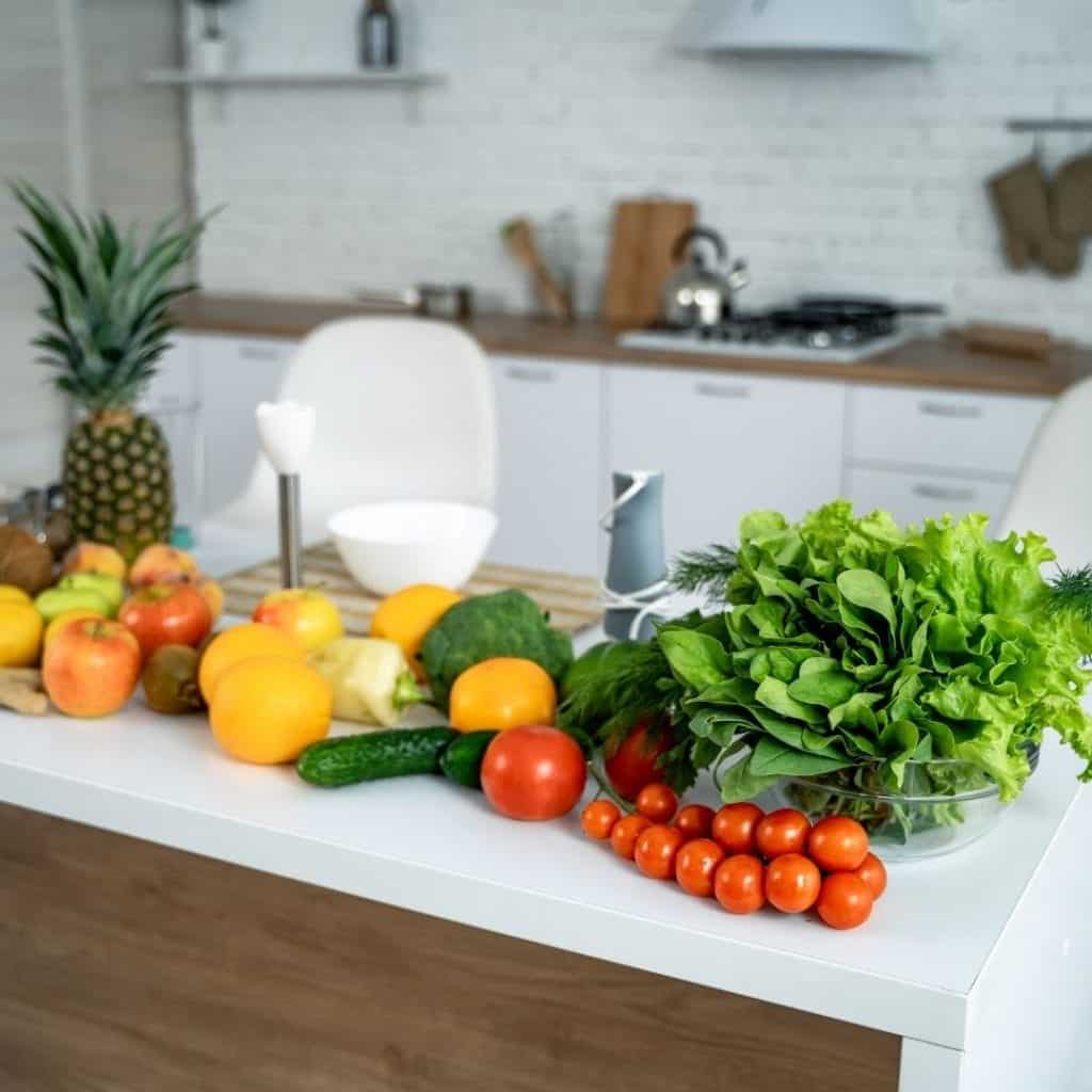 Healthy eating tips with fruits and vegetables on a white countertop.