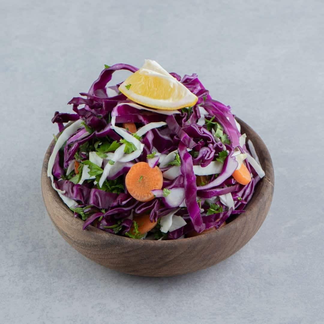 Cabbage, carrots, cilantro and lemon in a brown bowl. The easiest way to improve digestion.