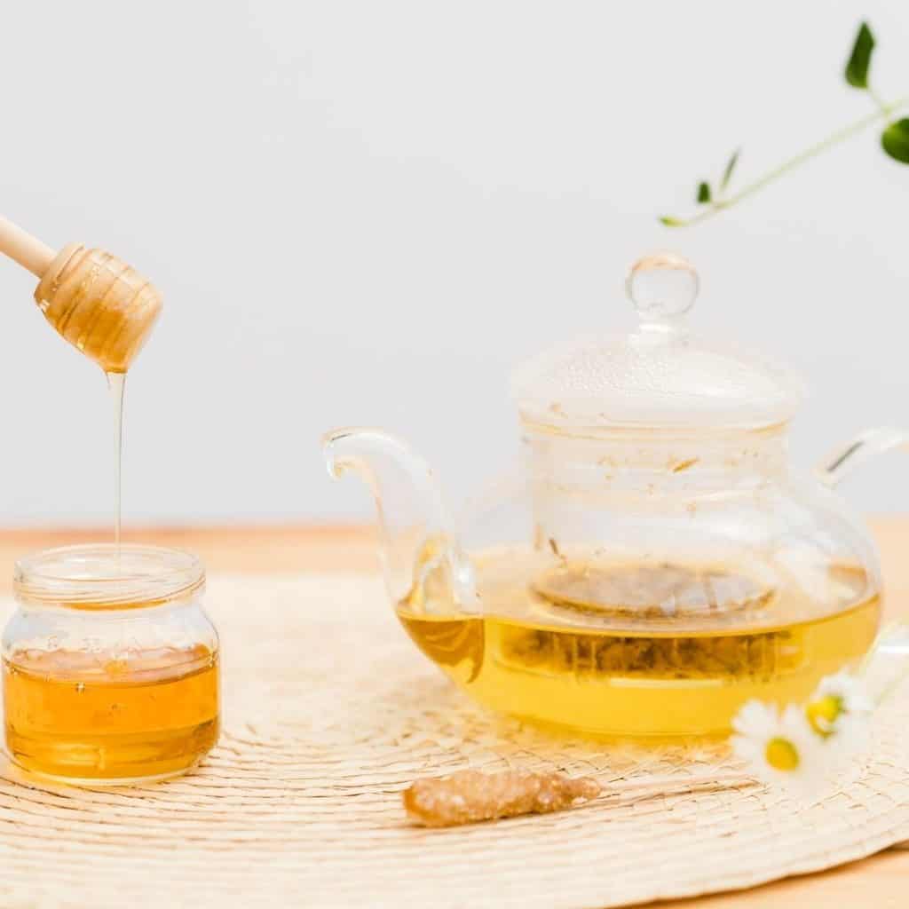 Honey cinnamon hot tea drink recipe in a glass teapot. 