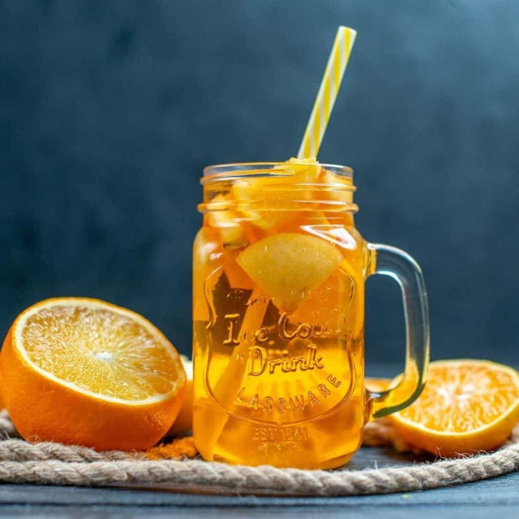 Honey cinnamon orange drink in a mason jar glass.
