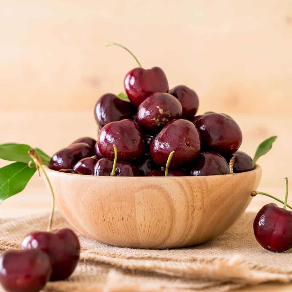 Cherries in a wooden bowl are excellent to eat for great sleep.