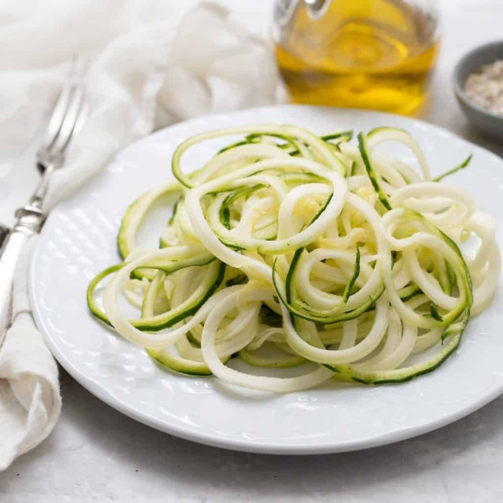 White plate of plain zoodles.