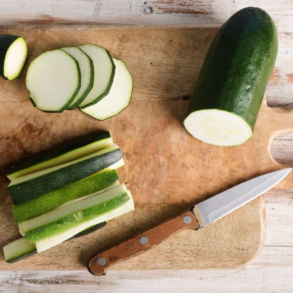 Cut zucchini on a cutting board. Benefits of eating raw zucchini.