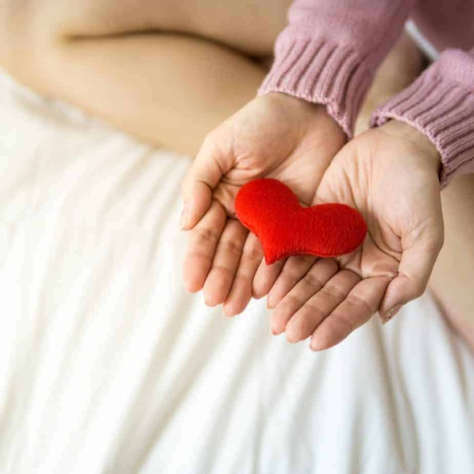 Woman holding a plush heart in hand for heart health and high blood pressure. 