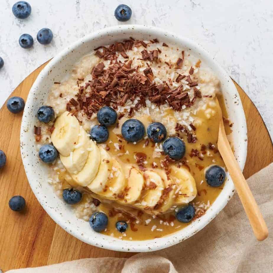 Lower blood pressure naturally with a bowl of oatmeal, bananas, and blueberries.