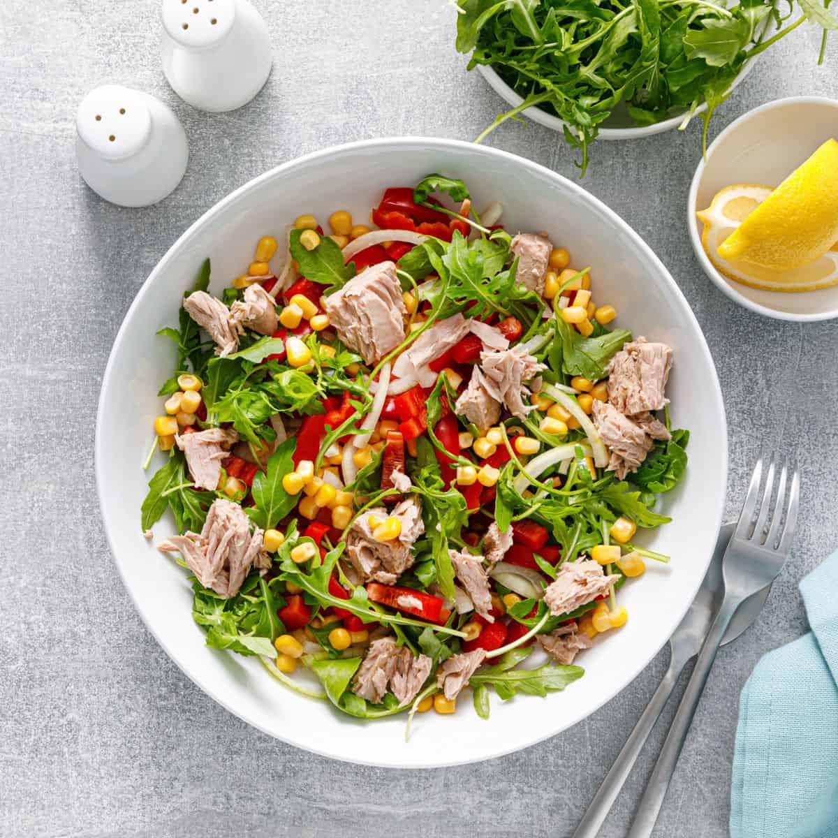 Healthy salad made with tuna arugula and fresh vegetables.