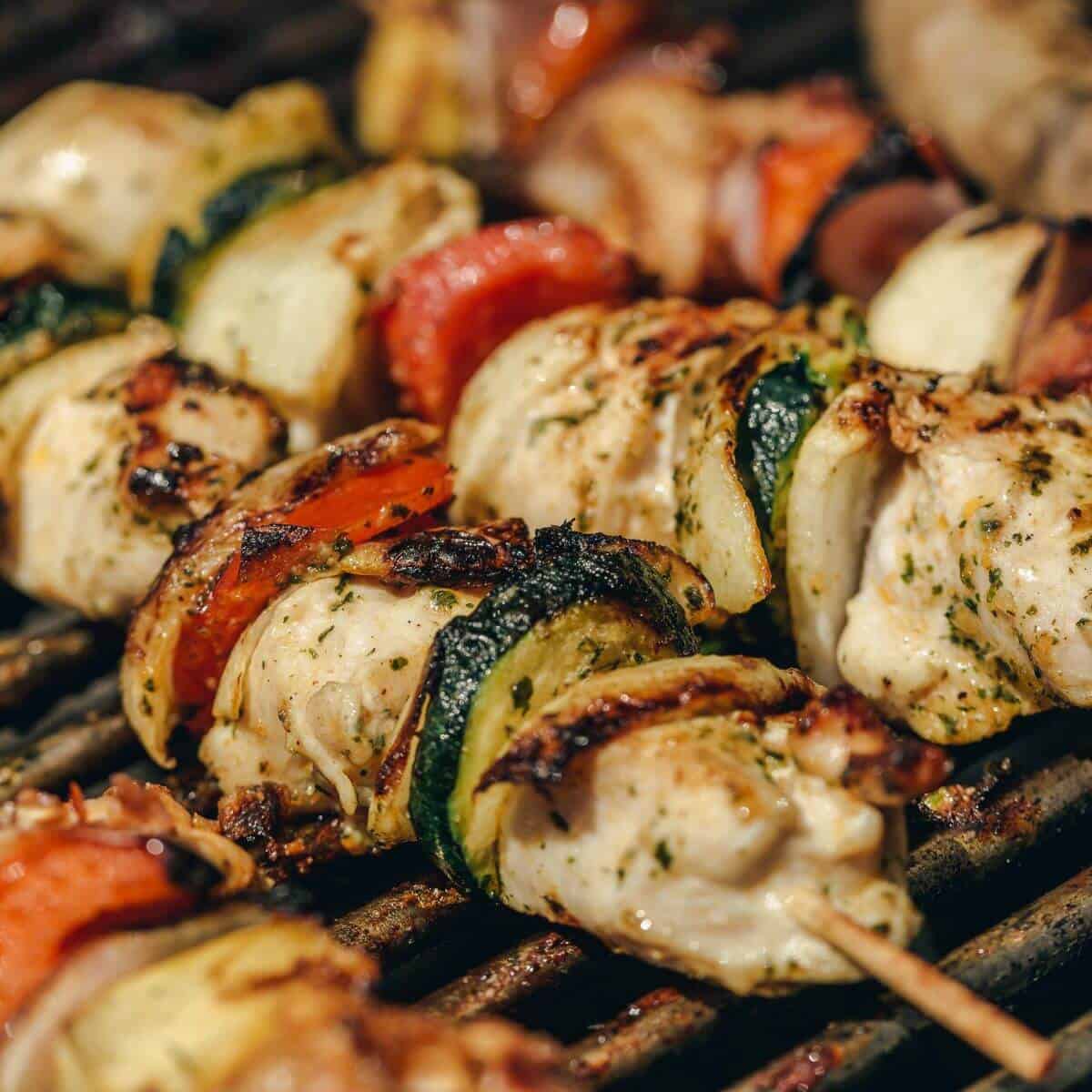 Grilling chicken kabob skewers with basil sauce