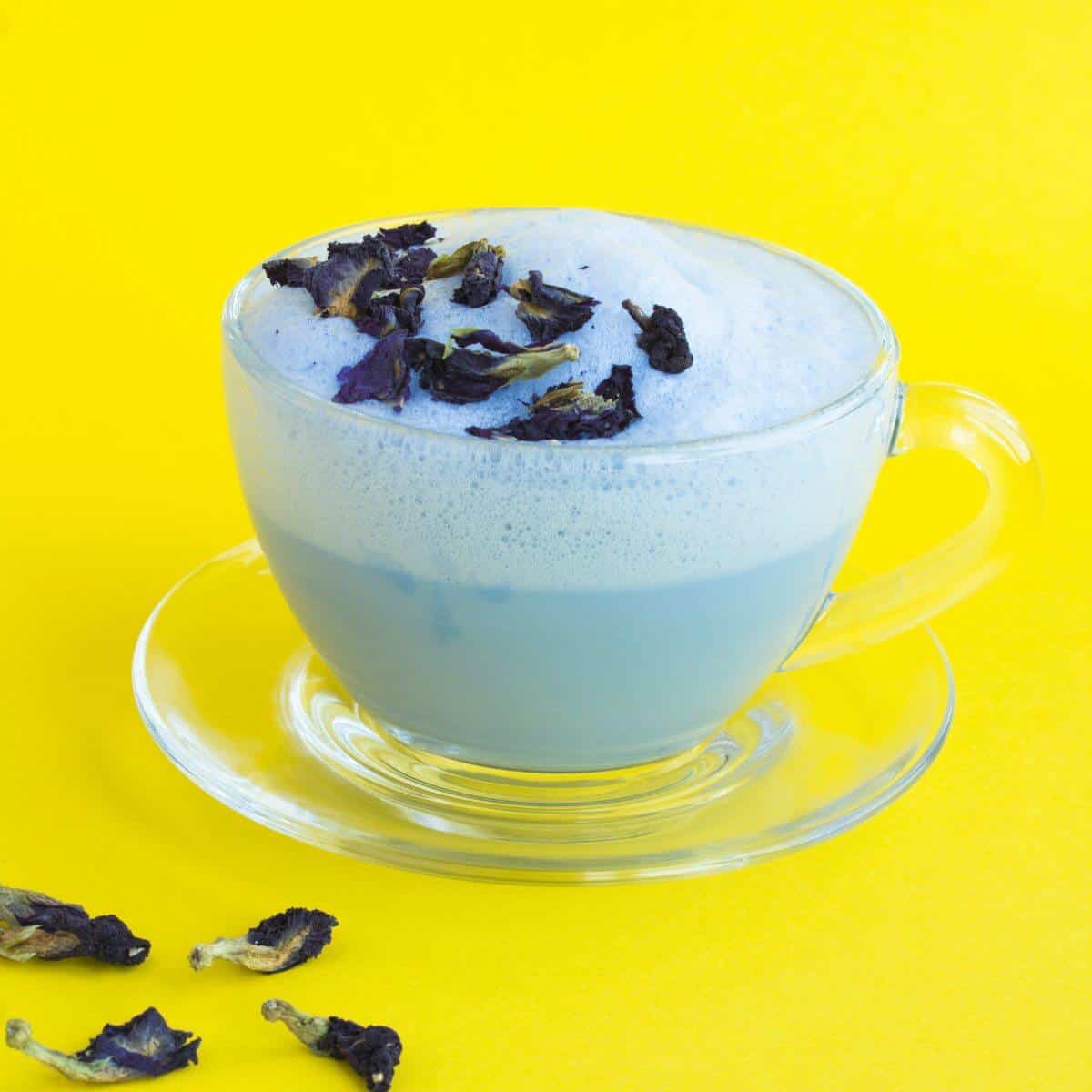 Ashwagandha moon milk with flower petals on a yellow background.