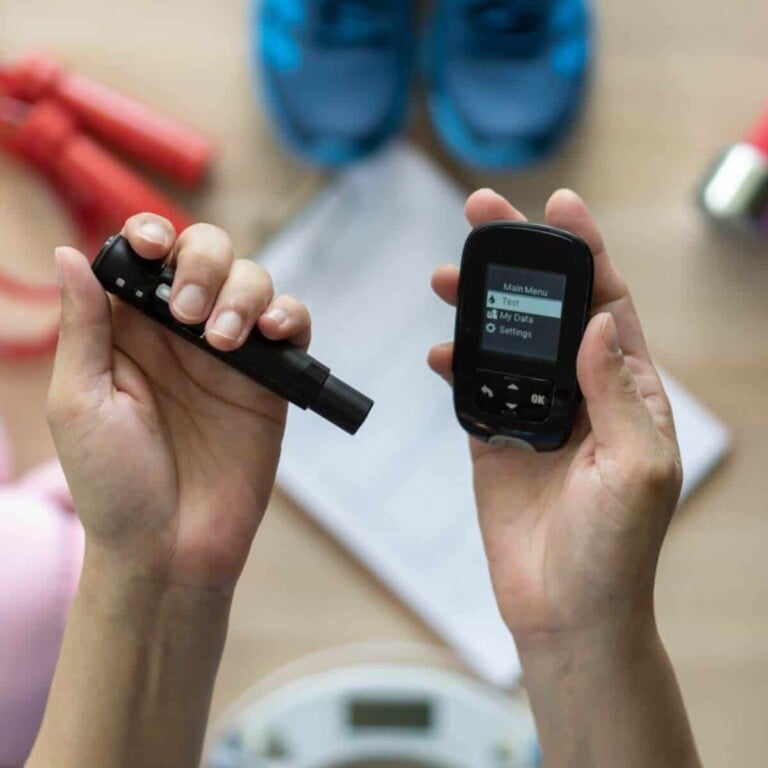 Hands holding a blood glucose meter