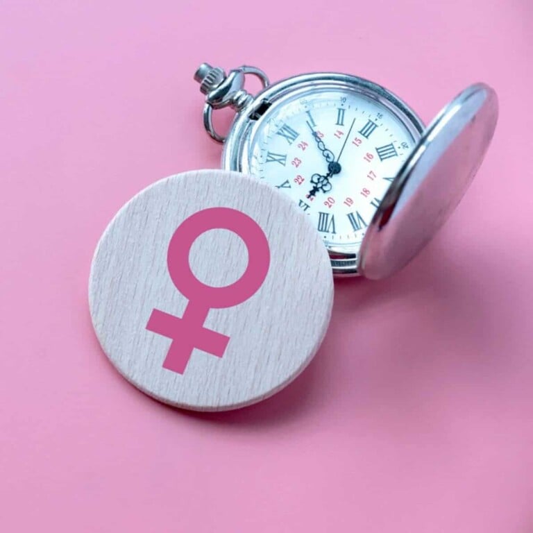 Female symbol next to a pocket watch