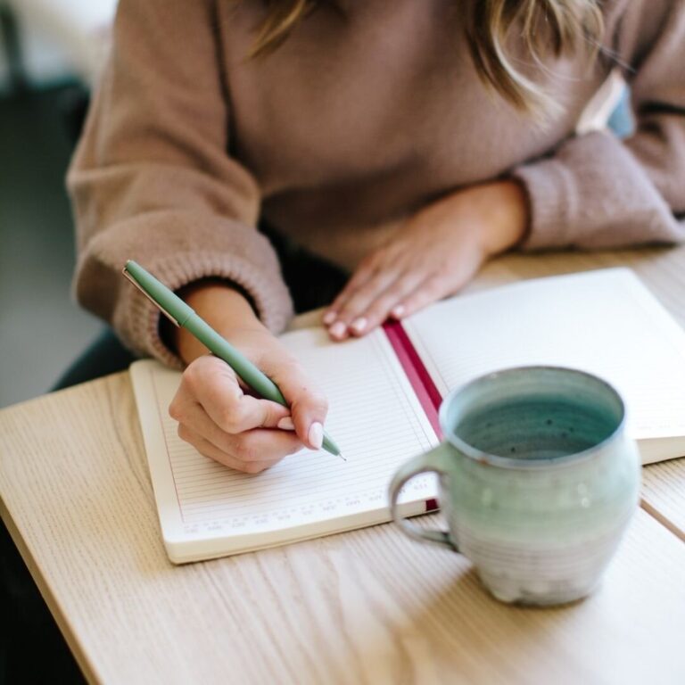 Writing a nutrition plan in a notebook during a coaching session